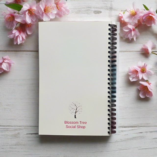 Photo of the back of positive notebooks, writing reads Blossom Tree Social shop