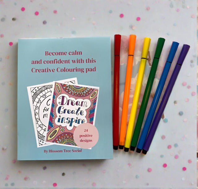 Coloured pens with colouring pad. Cover reads become calm and confident with this creative colouring pad, 24 positive designs by blossom tree social