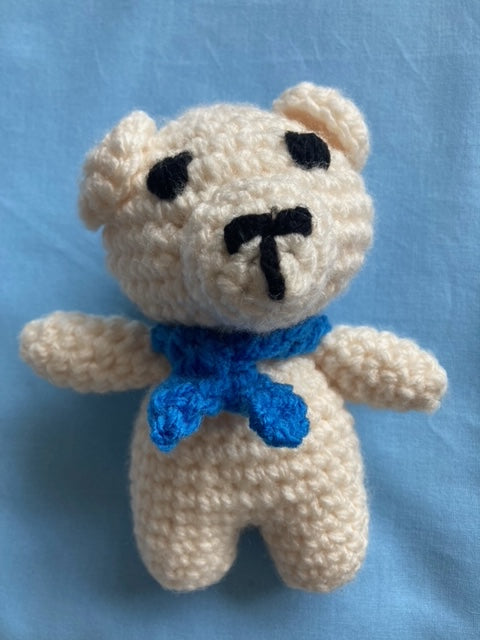 White handmade crochet bear with blue tie around neck