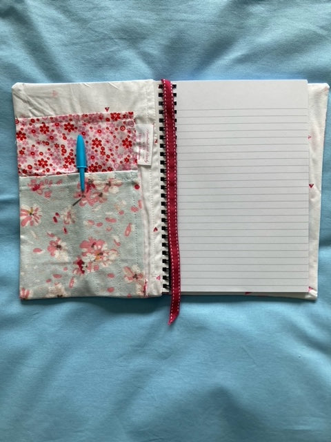 Inside of notebook cover, includes pocket for pens and spare paper