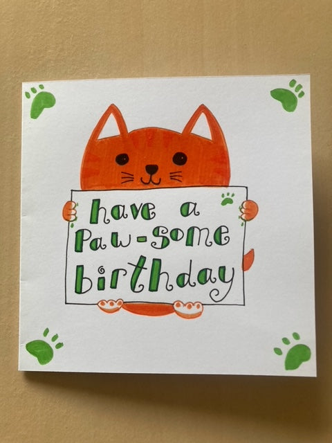 Handmade card with ginger cat holding a sign that says have a paw-some birthday