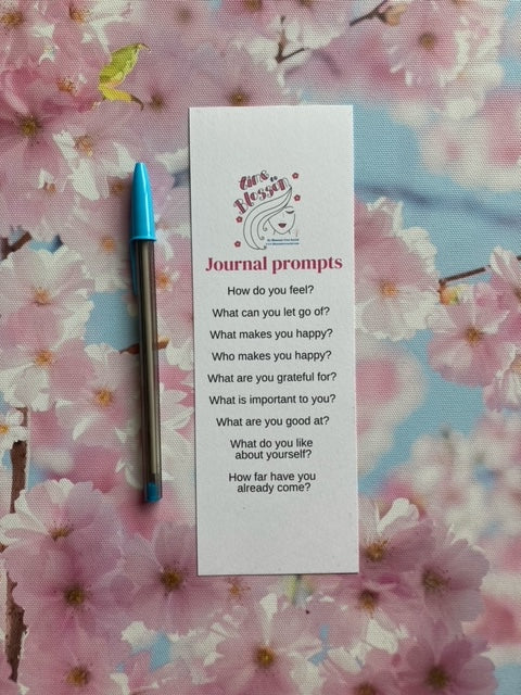 pen, Journal prompt bookmark includes 9 questions, with blossoms in the background