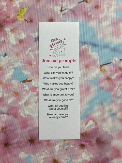 Journal prompt bookmark includes 9 questions, with blossoms in the background